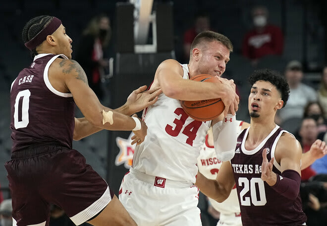 Texas A&M guard Aaron Cash (0) and guard Andre Gordon (20) pressure Wisconsin guard Brad Davison (34) during the first half of the Badgers' 11-point win.