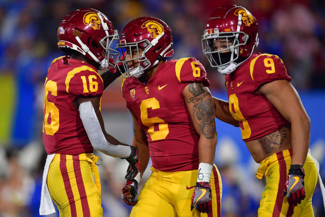 Running back Austin Jones, center, celebrates with receivers Tahj Washington, left, and Michael Jackson III during USC's win over UCLA on Saturday night.