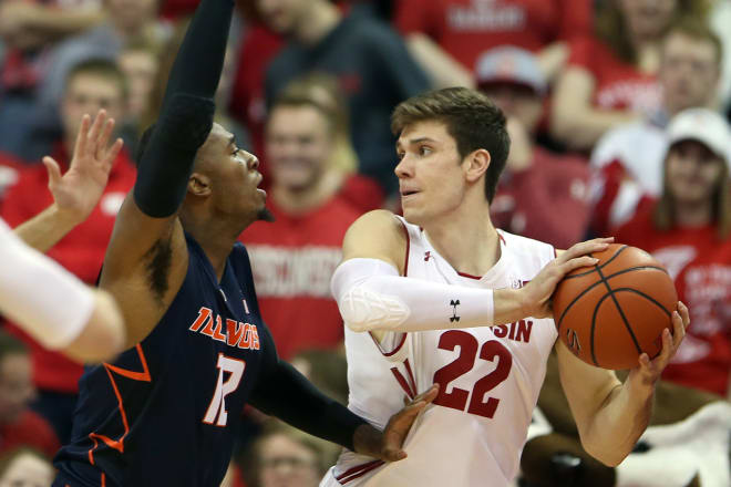 Wisconsin Badgers forward Ethan Happ (22) looks to pass as Illinois Fighting Illini forward Leron Black (12) during the first half defends at the Kohl Center. 