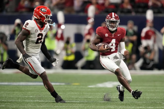 Alabama Crimson Tide quarterback Jalen Milroe (4) rushes the ball against Georgia Bulldogs linebacker Smael Mondon Jr. (2) during the first half in the SEC Championship game at Mercedes-Benz Stadium. Photo | Dale Zanine-Imagn Images