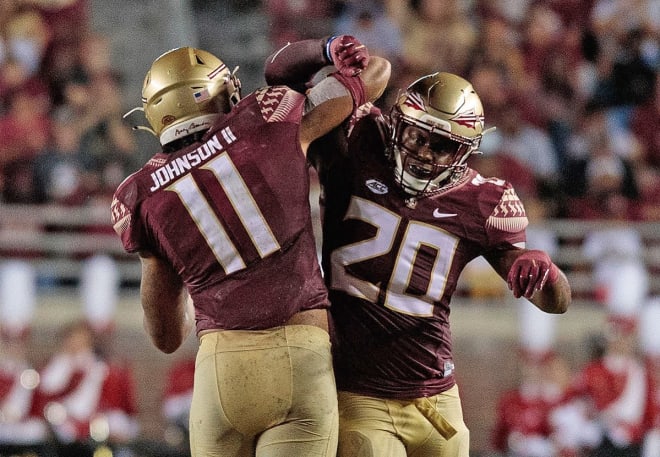 Jermaine Johnson celebrates a big play with linebacker Kalen DeLoach earlier this season.