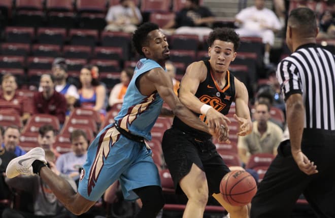 FSU guard Braian Angola deflects the ball from the hands of Oklahoma State's Jeffrey Carroll.
