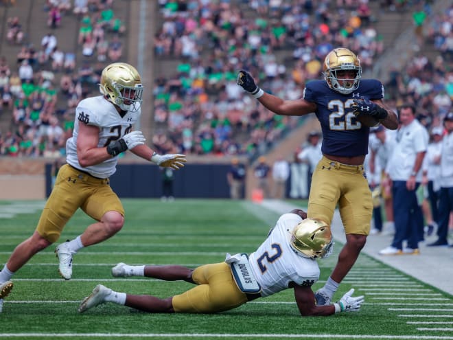 Notre Dame running back Logan Diggs (blue) tries to avoid a tackle by safety DJ Brown (2) and linebacker Jack Kiser in the 2021 Blue-Gold Game.