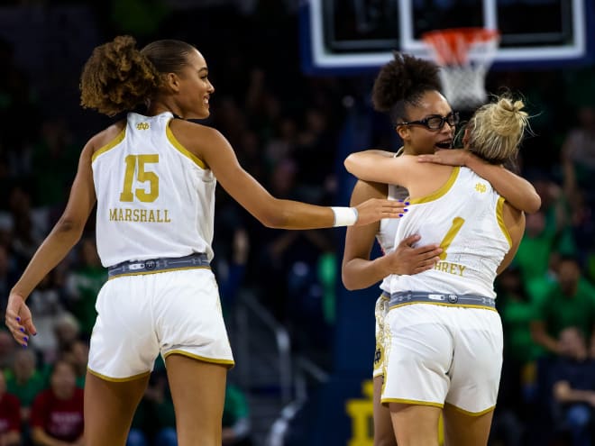 Notre Dame's Olivia Miles, center, hugs Dara Mabrey (1) as Natalija Marshall (15) smiles during Sunday's 74-60 win over UConn.