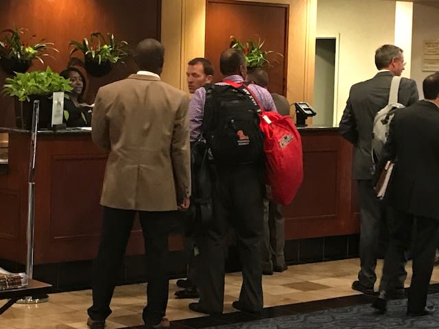 Ole Miss coaches Derrick Nix (left) and Maurice Harris (red bag) talk with Ross Bjork Tuesday afternoon. The coaches were flying back to Oxford tonight. 