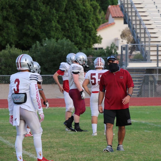 Chris Rizzo (right) gives advice at a Ironwood football practice.