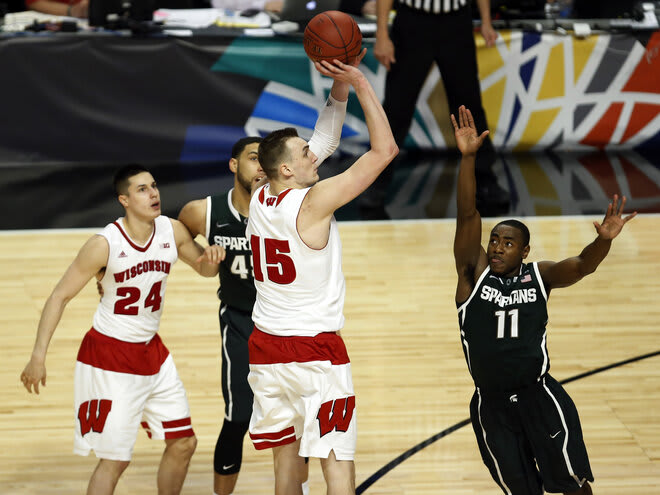 Wisconsin's Sam Dekker (15) shoots over Michigan State's Lourawls Nairn Jr. (11) in overtime of the 2015 Big Ten title game. The Badgers beat the Spartans to sweep the Big Ten titles.