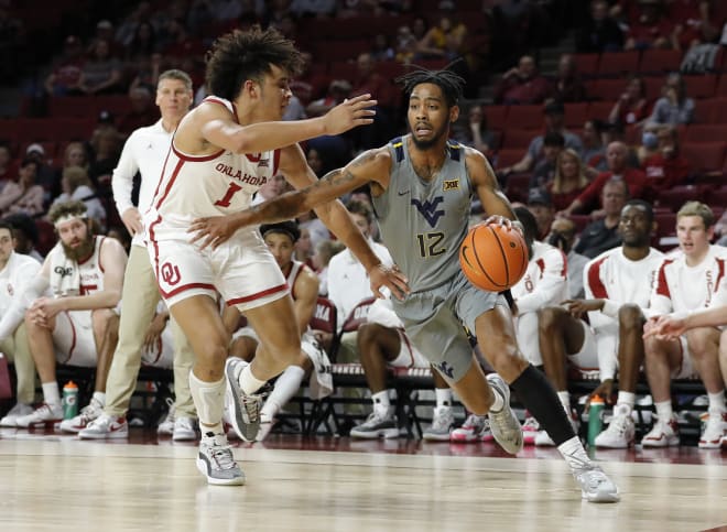 West Virginia Mountaineers guard Taz Sherman (12) drives to the basket around Oklahoma Sooners forward Jalen Hill (1) during the first half at Lloyd Noble Center.