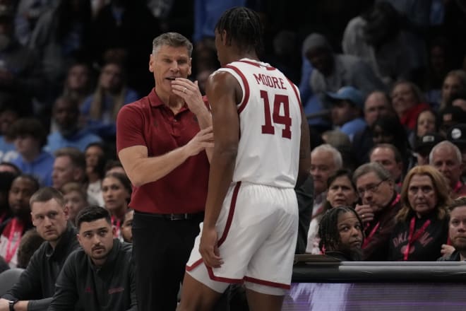 Oklahoma Sooners head coach Porter Moser talks with forward Jalon Moore (14) during a time out against the North Carolina Tar Heels during the first half at Spectrum Center.