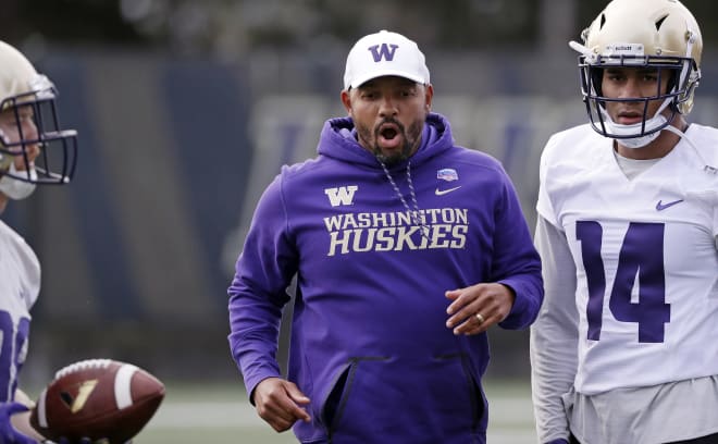 Washington co-defensive coordinator Jimmy Lake works with players at the first practice of spring football for the NCAA college team Wednesday, March 28, 2018, in Seattle. (AP Photo/Elaine Thompson).