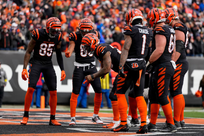 Cincinnati Bengals running back Joe Mixon (28) pulls a coin from his first band and flips it in the end zone after running in a touchdown in the first quarter of the NFL Week 18 game between the Cincinnati Bengals and the Baltimore Ravens at Paycor Stadium in downtown Cincinnati on Sunday, Jan. 8, 2023.