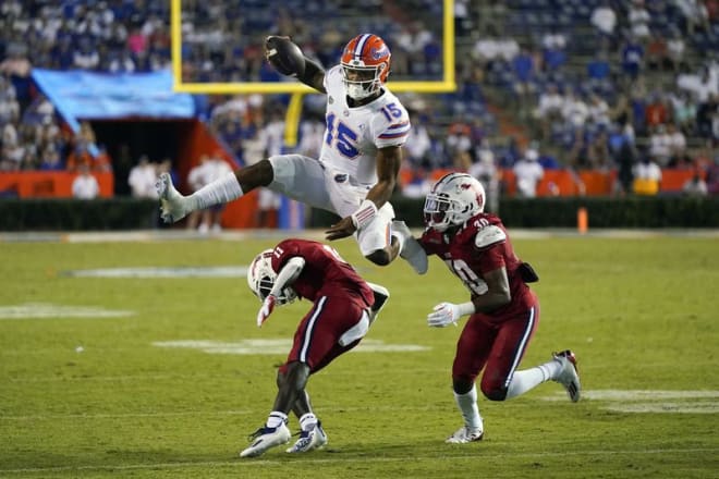 Florida quarterback Anthony Richardson (15) hurdles FAUdefensive back Justin McKithen (11) and safety Armani-Eli Adams (30) during the Gators' 35-14 win against the Owls to open the 2021 season. (John Raoux / AP)