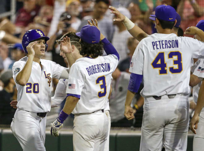 Antoine Duplantis (20) celebrates with teammates including Kramer Robertson (3) after he scored the go-ahead run against Florida State on a single by Greg Deichmann during the eighth inning