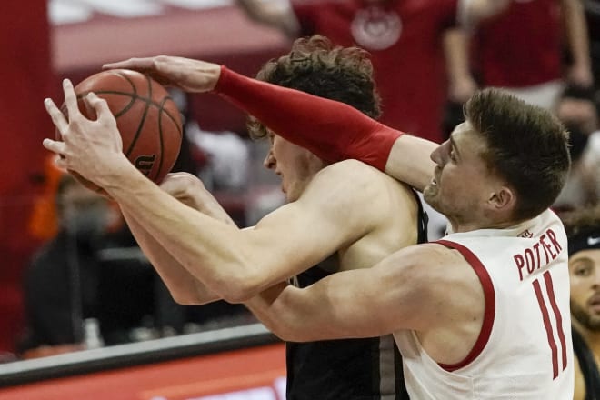 Wisconsin's Micah Potter and Minnesota's Liam Robbins battle for a loose ball