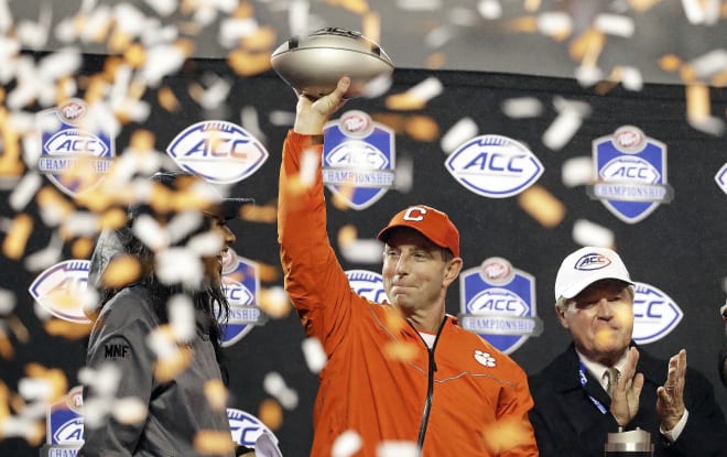Clemson head coach Dabo Swinney holds up a portion of the ACC Championship trophy late Saturday night in Bank of America Stadium.