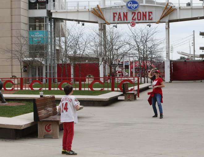 At left, Seneca Steinert (9) plays toss with his mother Anne Steinert, from Cincinnati, outside Great American Ball Park which would have been opening day with a game between the St. Louis Cardinals and the Cincinnati Reds.