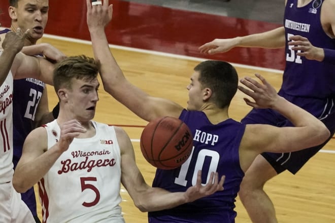 Wisconsin's Tyler Wahl and Northwestern's Miller Kopp go after a loose ball during the second half