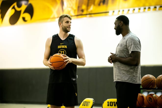 Ben Krikke and Tristan Spurlock, director of player development, chat during an Iowa practice this summer.