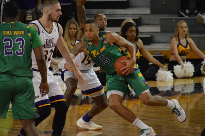 Tulane's Cam Reynolds drives by ECU's Kentrell Barkley in the Green Wave's 71-68 overtime win over the Pirates.