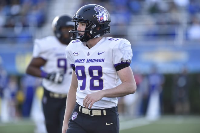 James Madison freshman punter Harry O'Kelly walks off the field this past Saturday during the Dukes' 20-10 win at Delaware in Newark, Del.
