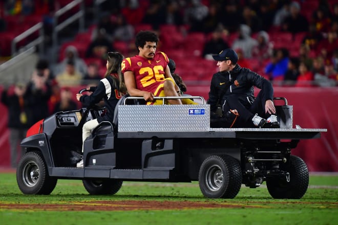 USC running back Travis Dye is carted off the field after appearing to twist his knee while being tackled.
