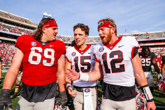 Carson Beck (15) and Brock Vandagriff (12) chat with Tate Ratledge.