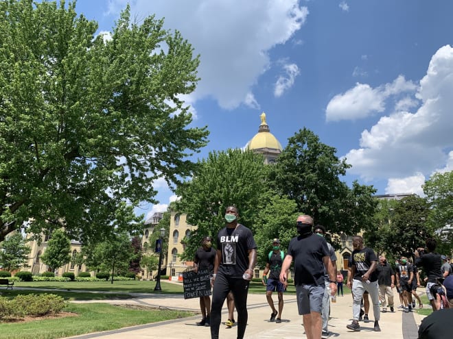 Notre Dame defensive end Daelin Hayes and head coach Brian Kelly lead football team and members of the Notre Dame community in a peaceful walk around campus.