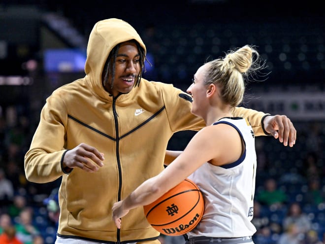 Detroit Pistons rookie Jaden Ivey, son of Notre Dame head coach Niele Ivey, greets Irish guard Dara Mabrey (right).