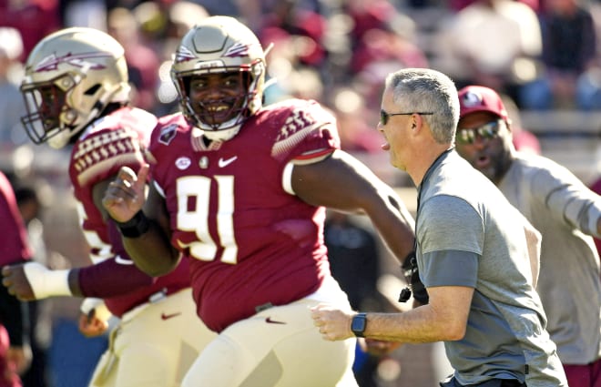 FSU football coach Mike Norvell playfully races defensive tackle Robert Cooper before the spring game.===[=