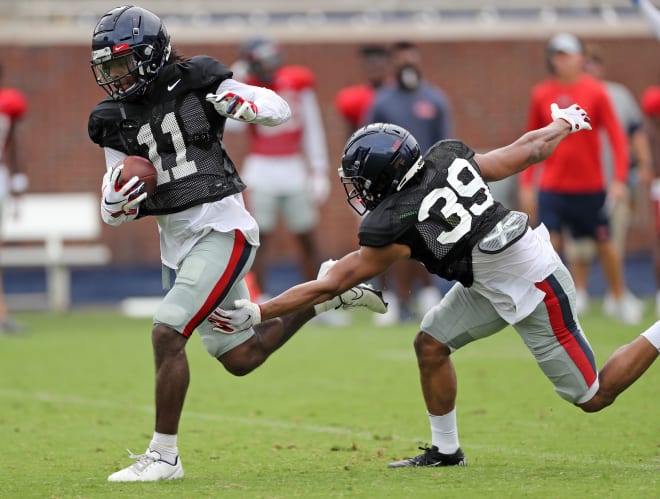 Ole Miss wide receiver Dontario Drummond (11) tries to avoid a tackle from safety Jake Springer during Sunday's scrimmage at Vaught-Hemingway Stadium.