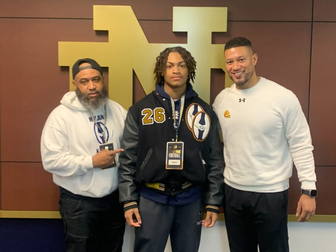 Four-star recruit Elbert Hill, a 2026 recruit in the middle, poses with Notre Dame head cah=od