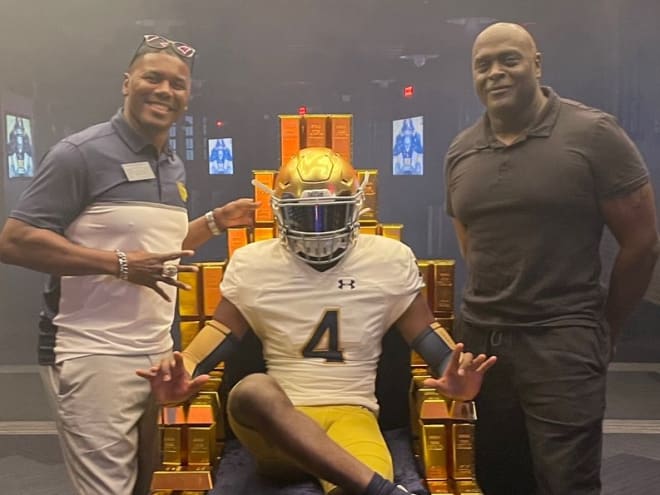 Running backs coach Deland McCullough (left), running back Jeremiyah Love (center) and father Jason Love (right) pose for a photo during a recruiting visit.
