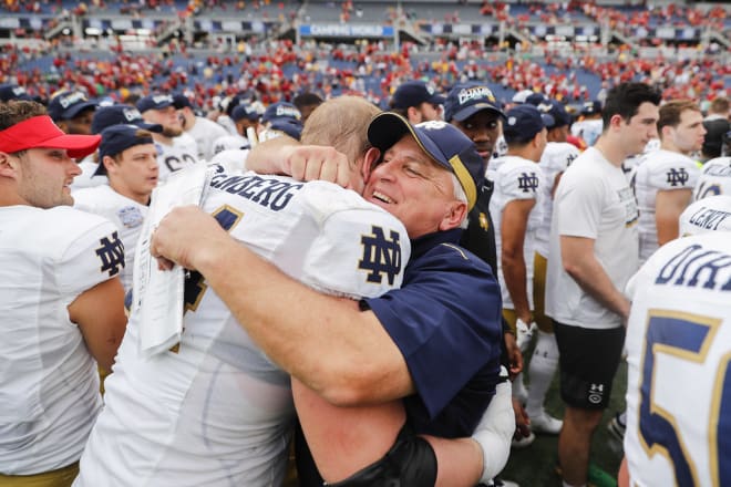 Notre Dame offensive line coach Jeff Quinn embracing left tackle Liam Eichenberg after a win over Iowa State in the Camping World Bowl