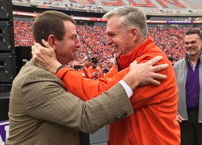 An emotional Clemson head coach Dabo Swinney connects with former Clemson athletics director Terry Don Phillips Saturday in Death Valley, while Board of Trustee member Bill Smith looks on.