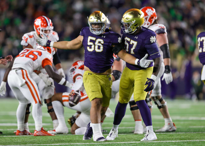 Notre Dame defensive linemen Howard Cross III (560 and Jayson Ademilola (57) celebrate after a sack. 