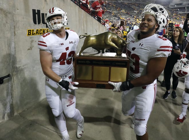 Wisconsin linebackers Ryan Connelly, left, and T.J. Edwards, carry the Heartland Trophy off the field after the team's win over Iowa in Iowa City in 2018.