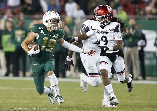 Nov 16, 2019; Tampa, FL; South Florida Bulls wide receiver Bryce Miller (19) is chased by Cincinnati Bearcats cornerback Arquon Bush (9) at Raymond James Stadium.