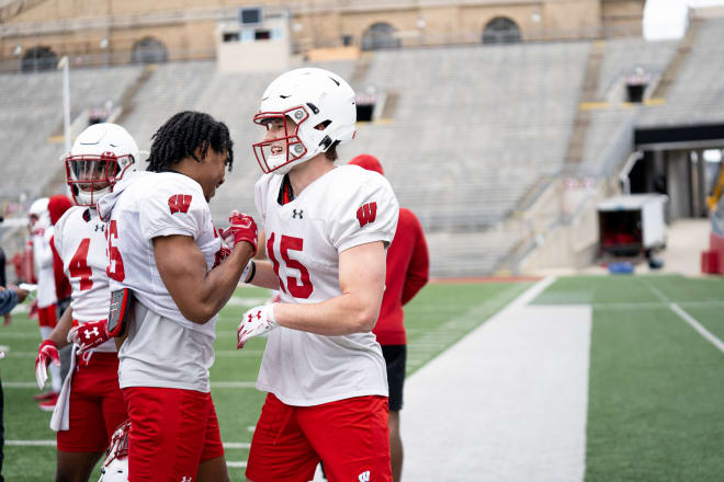 John Torchio (15) celebrates with safety Travian Blaylock (left) during a Wisconsin spring practice.