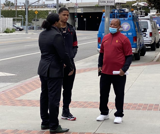 Munir McClain stands in the middle of supporters Kumasi Simmons, left, and, Najee Ali before his family's news conference outside Galen Center on Sunday.