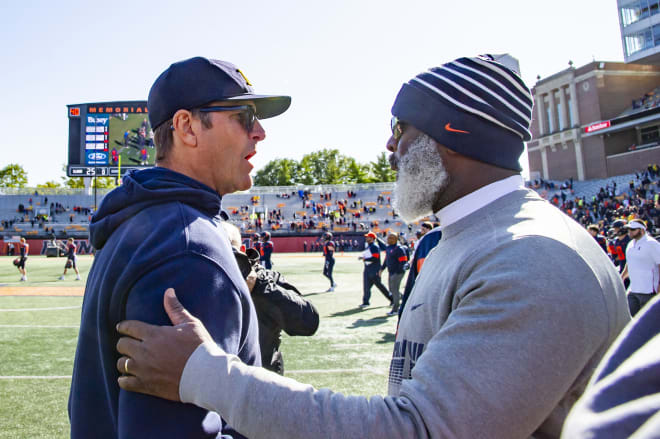 Michigan football's Jim Harbaugh and Illinois coach Lovie Smith greet each other after Michigan's 42-25 win.