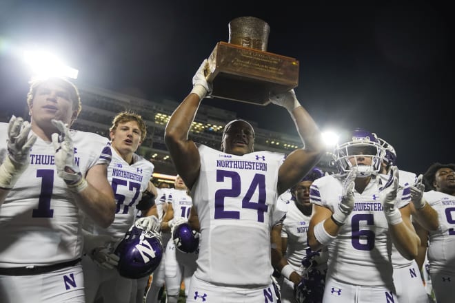 Rod Heard II holds the Land of Lincoln Trophy aloft after Northwestern's 45-43 win over Illinois.