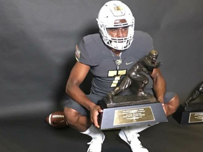 Rivals 3-star QB commit Dedrick Wilson posses with Heisman Trophy during his official visit this weekend