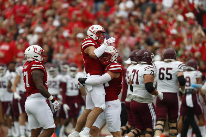 Nebraska LB Garrett Nelson picks up LB JoJo Domann to celebrate his Domann's first career interception