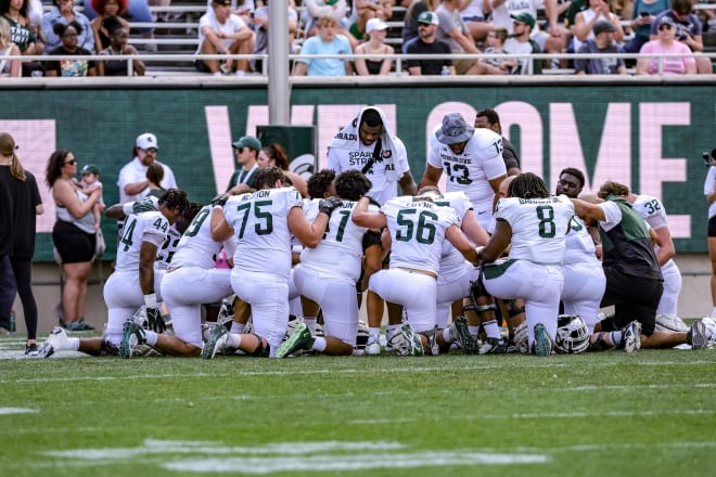 MSU's defense huddles up on the field at the "Spartan Football Kickoff" event