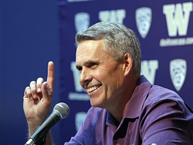 Washington NCAA college head football coach Chris Petersen points skyward in response to hearing Blue Angels jets soar nearby as he speaks at a news conference Thursday, Aug. 2, 2018, in Seattle. Petersen hates expectations, so he's likely loathing Washington being the overwhelming favorite in the Pac-12 and likely top 10 when the preseason AP poll comes out. The Huskies open fall camp on Friday in preparation for the Sept. 1 opener against Auburn. (AP Photo/Elaine Thompson)
