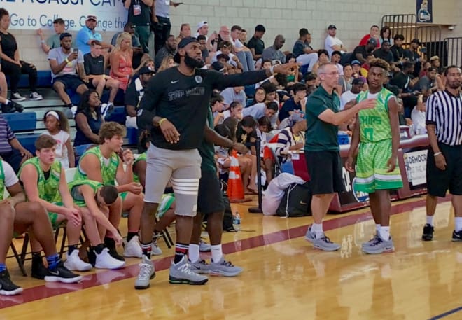 Assistant coach LeBron James directs his team as his son LeBron James Jr. (0) look on.