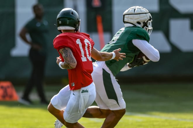 Quarterbacks Noah Kim (No. 10) hands the ball off to running back Jalen Berger (No. 8)