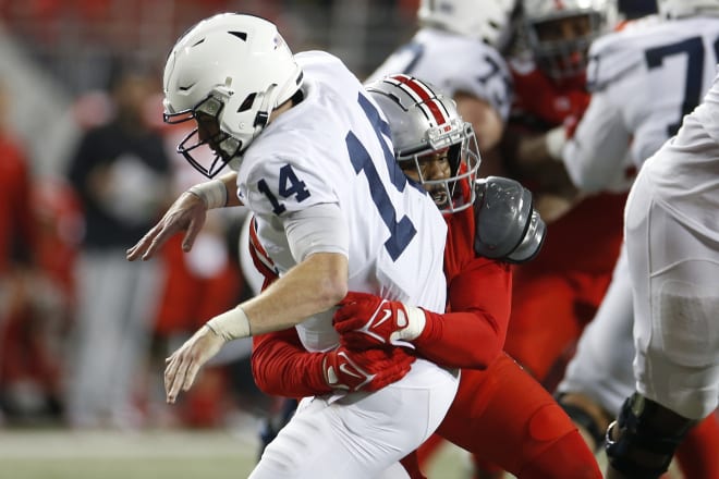 Ohio State defensive lineman Tyreke Smith, rear, hits Penn State's Sean Clifford during the second half of an NCAA college football game Saturday, Oct. 30, 2021, in Columbus, Ohio. Ohio State won 33-24. (AP Photo/Jay LaPrete)