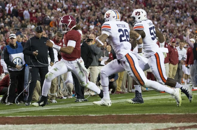 Alabama Crimson Tide quarterback Jalen Hurts (2) runs to the goal line as he is pursued by Auburn Tigers defensive back Tray Matthews (28) and defensive lineman Carl Lawson (55) at Bryant-Denny Stadium. The Tide defeats the Tigers 30-12. Photo | USA Today
