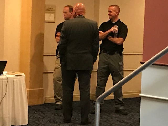 Armed security agents and an NCAA official (back turned) guard the entrance to the ballroom inside the Embassy Suites Cincinnati RiverCenter. The ballroom is host to Ole Miss' hearing in front of the NCAA's Committee on Infractions. 